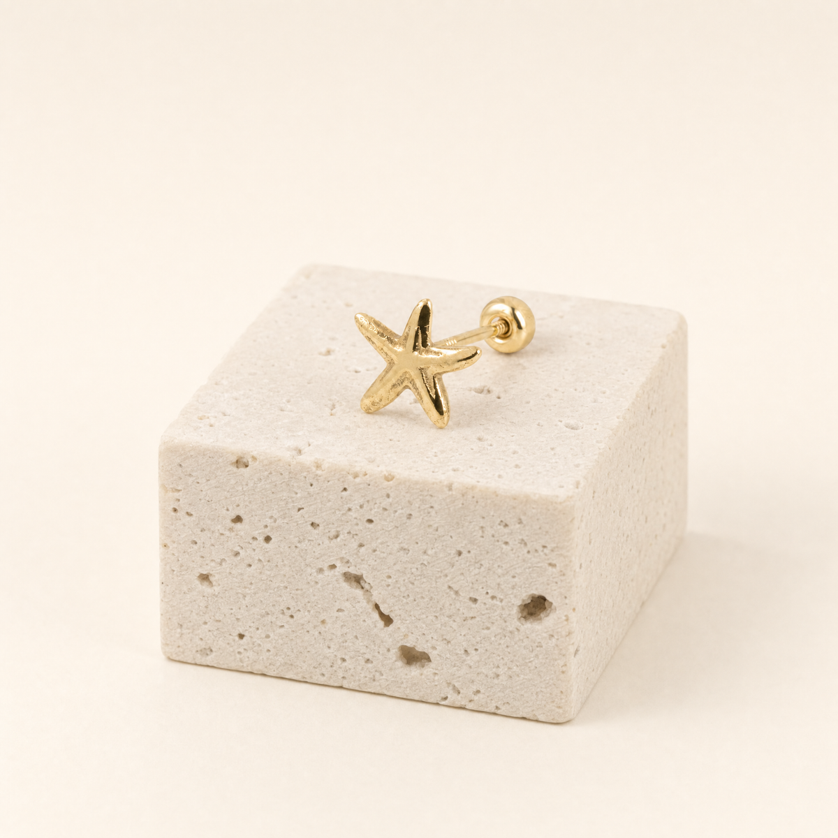 Broquel estrella de mar de oro 10k, una pieza sobre piedra clara