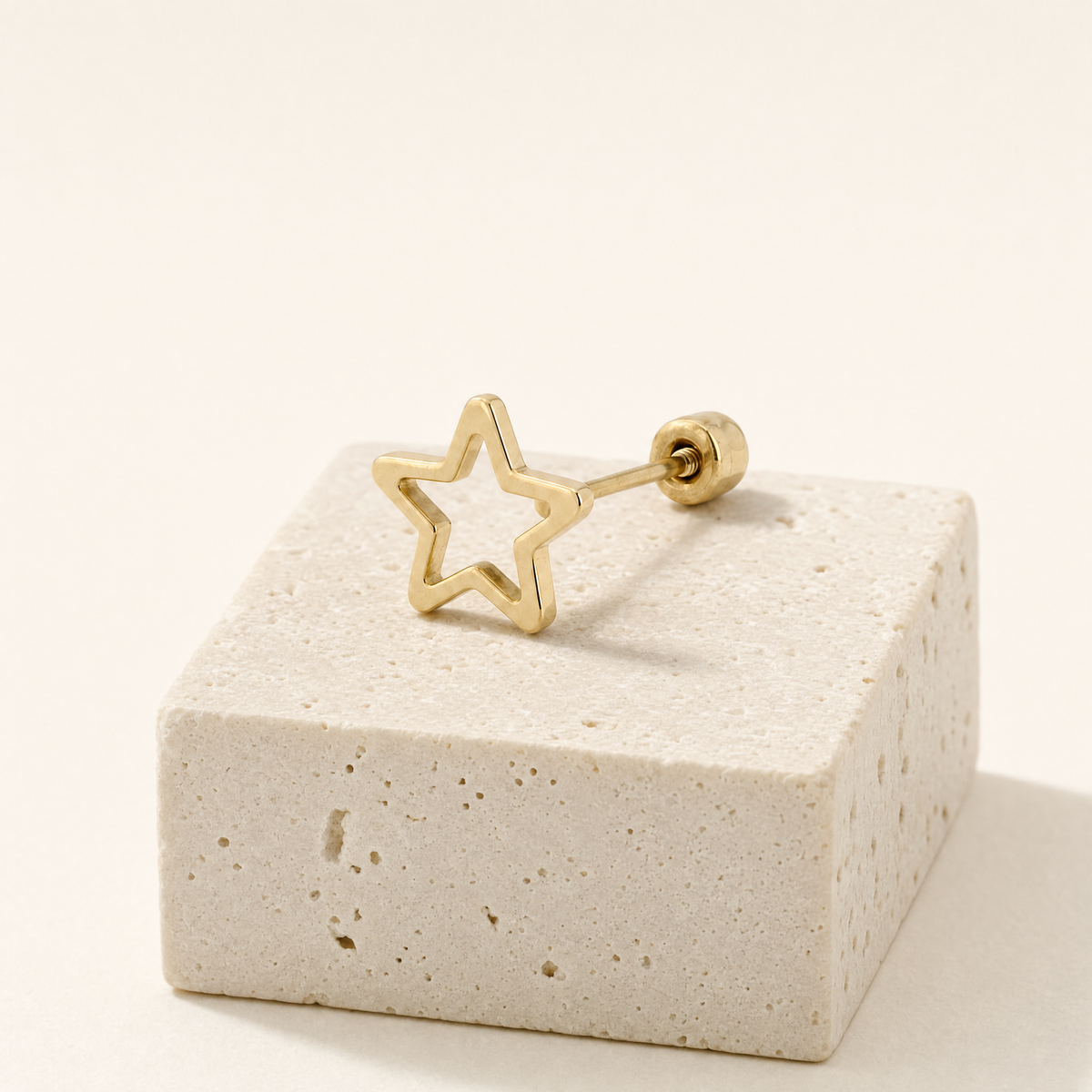 Broquel silueta estrella de oro 10k, una pieza sobre piedra clara