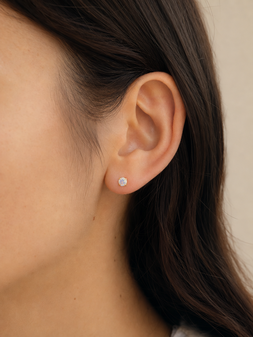 Broquel Solitario Zirconia Tornasol 4 mm Oro 10K puesto — modelo