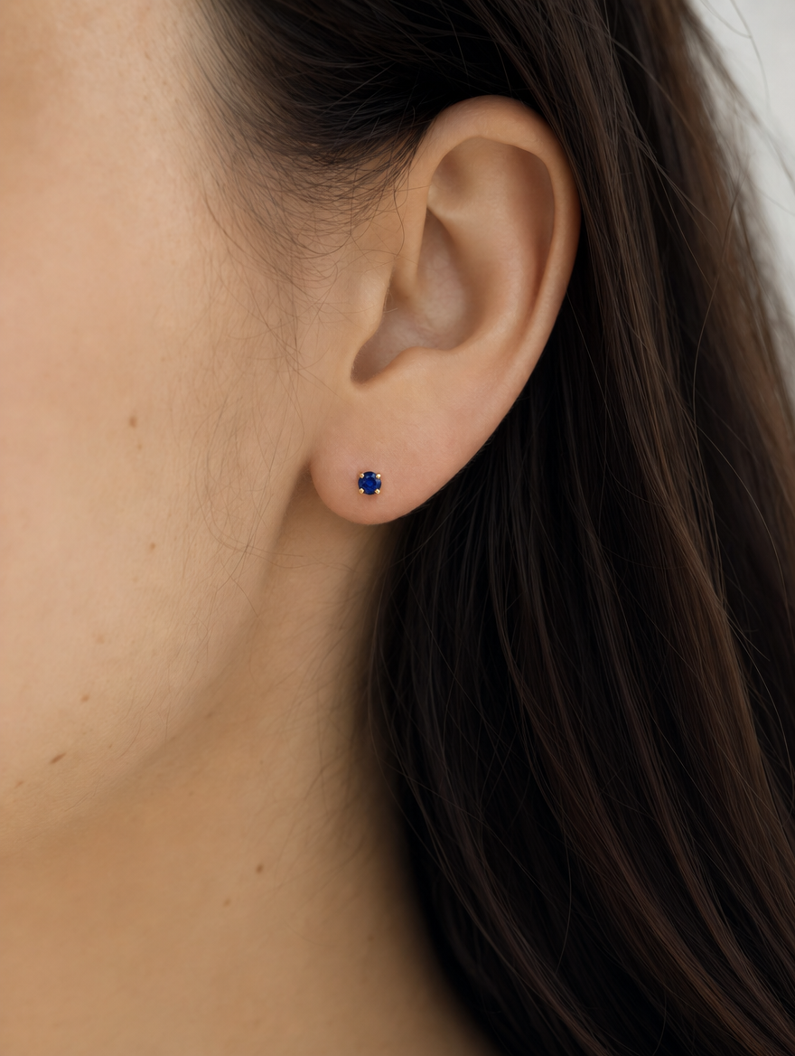 Broquel Solitario Zirconia Azul 4 mm Oro 10K puesto — modelo