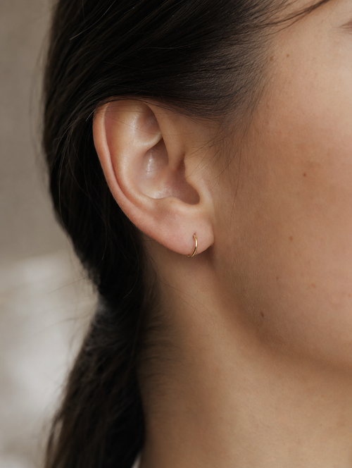 Arracada Lisa 6.6 mm Oro 10K puesto — modelo
